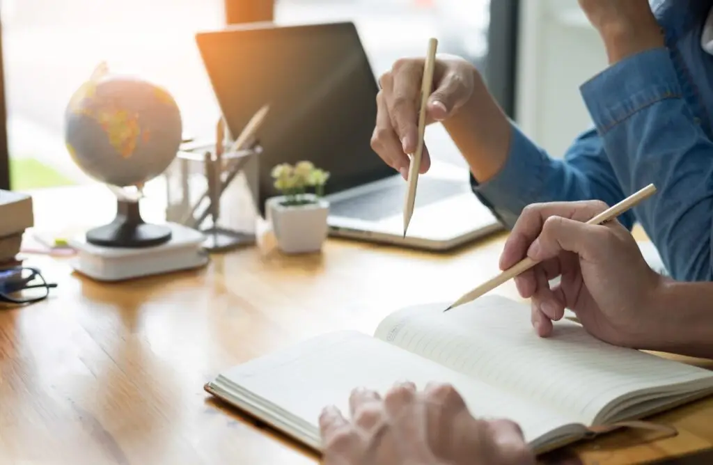 Tutor and student working through notes at a desk