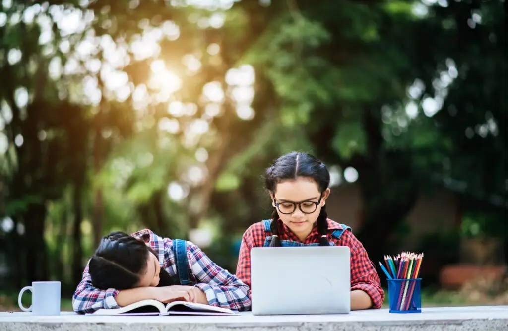 Two students studying at an outdoor table